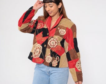 May include: A red, black, and brown patchwork jacket with floral embroidery. The jacket has a button closure and a collar.
