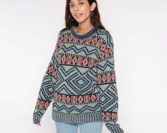 May include: A blue, green, and red patterned sweater with a crew neck. The sweater has a geometric design.