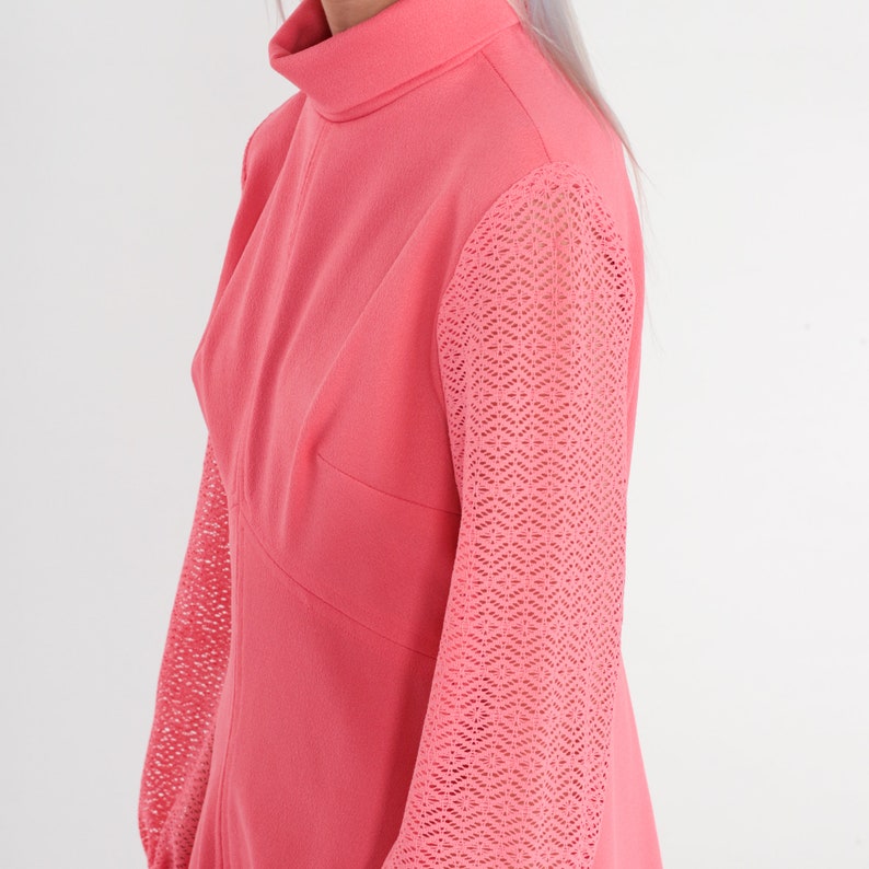 May include: A pink dress with a high neck and long sleeves. The sleeves are made of a delicate, lacy material.