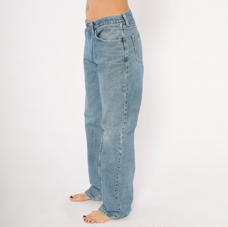 Peut inclure: Jean en denim bleu clair avec une conception classique &agrave; cinq poches. Le jean a une coupe droite et un d&eacute;lavage d&eacute;color&eacute;, offrant une esth&eacute;tique vintage. Le jean est en denim durable.