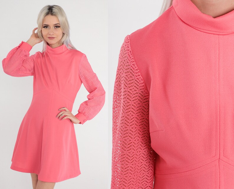 May include: A pink dress with a high neck and long sleeves. The sleeves are made of a lacy material. The dress has a fitted bodice and a flared skirt.