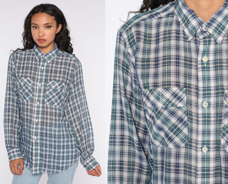 Op de afbeelding: Een geruit shirt met lange mouwen in tinten blauw, groen en wit. Het shirt heeft een knoopsluiting, een kraag en twee borstzakken. Het ruitpatroon is een klassiek ontwerp.