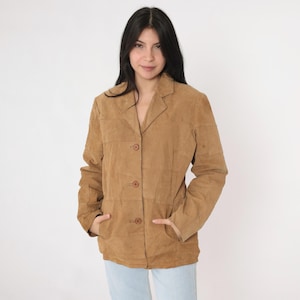 May include: A brown suede jacket with a button-up front and long sleeves. The jacket has a collar and two pockets.