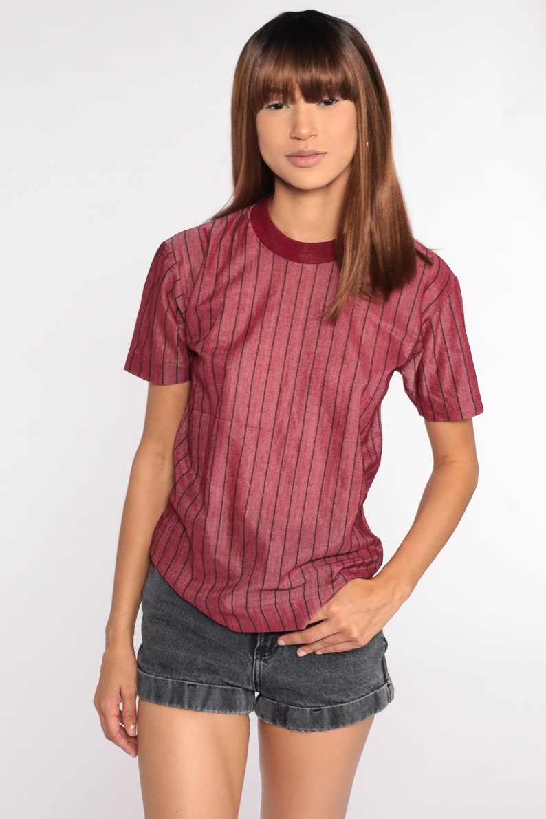 May include: A red and black striped short-sleeved shirt with a crew neck.