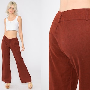 May include: A pair of wide-leg pants in a rich rust brown color. The pants have a high waist and a straight leg.