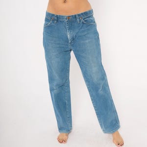 Puede incluir: Vaqueros de mezclilla azul claro con un dise&ntilde;o cl&aacute;sico de cinco bolsillos. Los vaqueros tienen un corte de pierna recta y un cierre de bot&oacute;n y cremallera. El denim tiene un lavado descolorido, d&aacute;ndole un aspecto vintage. Los vaqueros son de estilo casual.