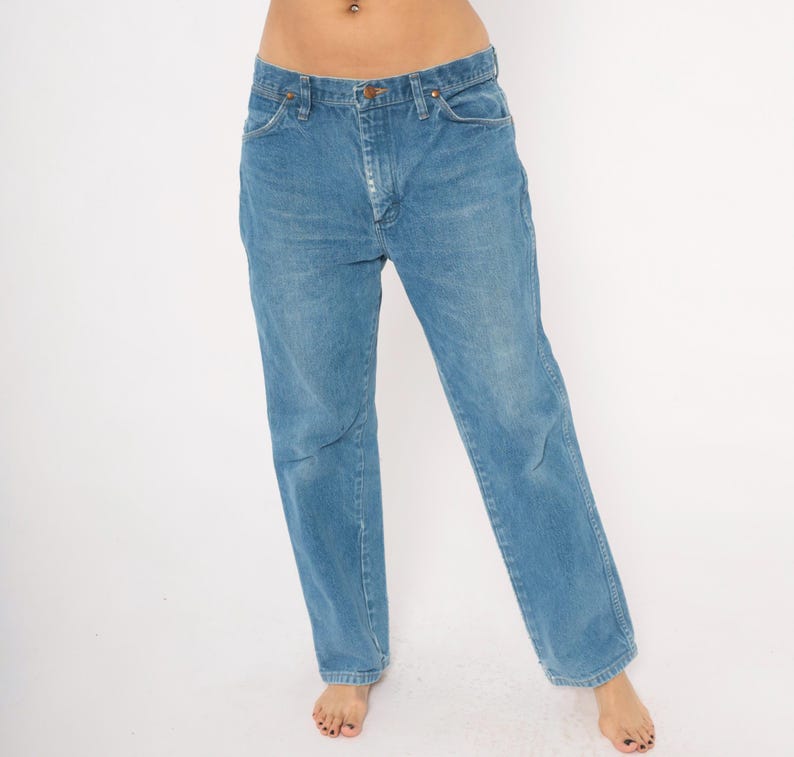 Puede incluir: Vaqueros de mezclilla azul claro con un dise&ntilde;o cl&aacute;sico de cinco bolsillos. Los vaqueros tienen un corte de pierna recta y un cierre de bot&oacute;n y cremallera. El denim tiene un lavado descolorido, d&aacute;ndole un aspecto vintage. Los vaqueros son de estilo casual.