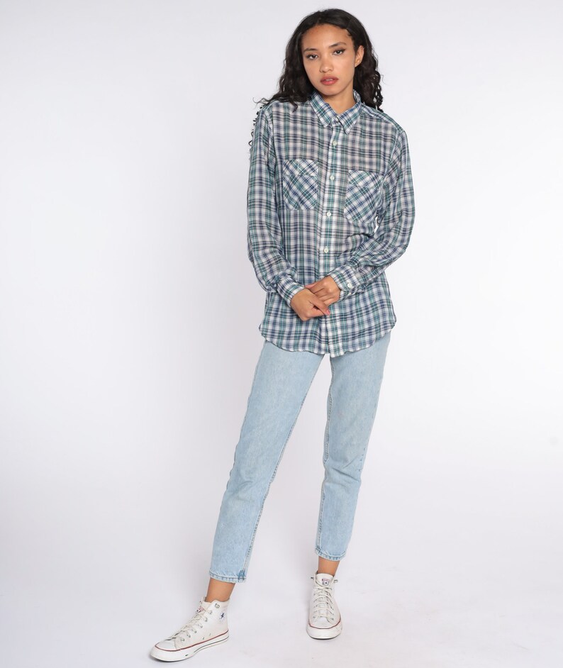 Op de afbeelding: Een geruit overhemd in groen, blauw en wit, gecombineerd met lichtblauwe jeans en witte hoge sneakers. Het overhemd heeft twee borstzakken en lange mouwen. Het model staat voor een witte achtergrond.