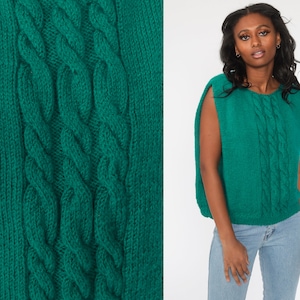 May include: A teal blue knitted sleeveless sweater with a cable knit pattern.
