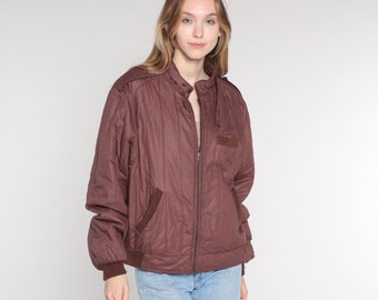 May include: A brown quilted jacket with a zipper closure and a stand-up collar.