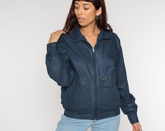 May include: A navy blue bomber jacket with a zipper closure and a small pocket on the left chest. The jacket has a  "Members Only" logo on the right chest.