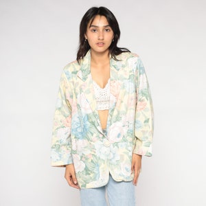 May include: A yellow floral print blazer with a single button closure. The blazer has a relaxed fit and long sleeves.