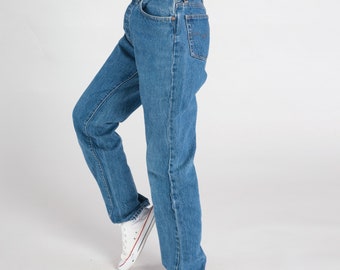 May include: A pair of blue denim jeans with a straight leg fit. The jeans have a classic five-pocket style and a button fly.
