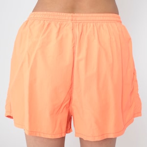 May include: A pair of bright orange athletic shorts with an elastic waistband.