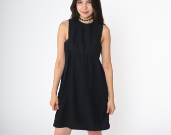 May include: A black sleeveless dress with a scoop neck and a fitted bodice. The dress has a slightly flared skirt and falls just above the knee.