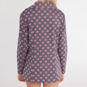 Puede incluir: Una camisa de manga larga con fondo azul marino y un peque&ntilde;o estampado floral rosa.