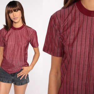 May include: A red striped short-sleeved t-shirt with a crew neck.