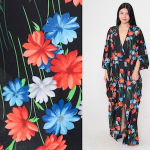 May include: A black maxi dress with a deep V-neckline and a floral print featuring red, blue, and white flowers. The dress has a flowing silhouette and a long, flowing skirt.