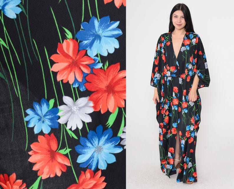 May include: A black maxi dress with a deep V-neckline and a floral print featuring red, blue, and white flowers. The dress has a flowing silhouette and a long, flowing skirt.