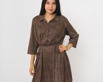 May include: A brown, button-down dress with a subtle floral pattern. The dress features a collared neckline, three-quarter sleeves, and a matching belt cinching the waist. The dress is knee-length.