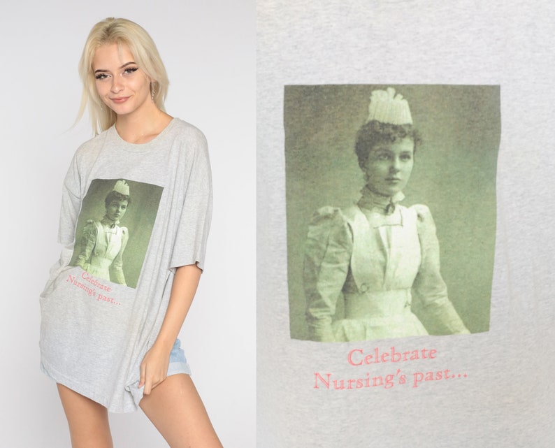 May include: A gray t-shirt with a vintage photo of a nurse wearing a white uniform and a white cap. The text on the shirt reads "Celebrate Nursing's Past..."
