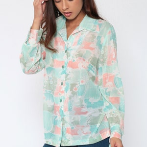 Puede incluir: Camisa abotonada de manga larga con un estampado abstracto en tonos pastel en verde menta, melocot&oacute;n y gris. La blusa tiene cuello y se combina con vaqueros azules. El dise&ntilde;o de la camisa presenta una tela suave y fluida.