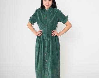 May include: A green corduroy midi dress with a button-up front and short sleeves. The dress has a fitted bodice and a full skirt.