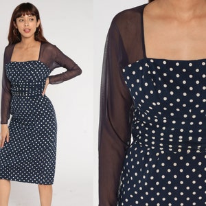 May include: A navy blue dress with white polka dots and a matching sheer navy blue long-sleeved shrug.