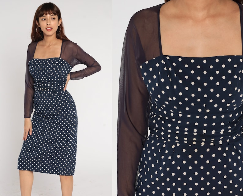 May include: A navy blue dress with white polka dots and a matching sheer navy blue long-sleeved shrug.