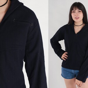 May include: A black long-sleeved shirt with a v-neck and a hood. The shirt has a relaxed fit and is made of a soft, comfortable fabric.