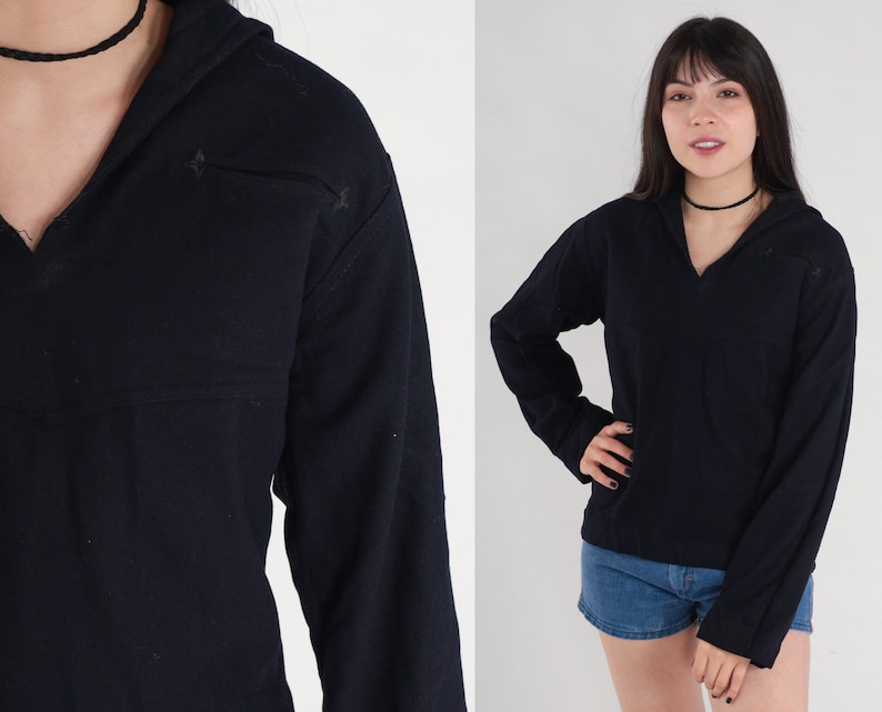 May include: A black long-sleeved shirt with a v-neck and a hood. The shirt has a relaxed fit and is made of a soft, comfortable fabric.