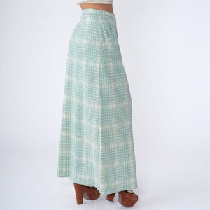 May include: A long, flowing skirt with a light blue and white plaid pattern. The skirt is made of a soft, lightweight fabric and has a relaxed fit.