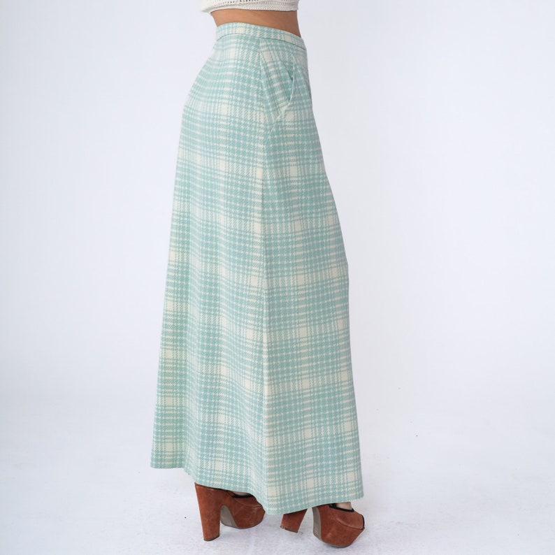 May include: A long, flowing skirt with a light blue and white plaid pattern. The skirt is made of a soft, lightweight fabric and has a relaxed fit.