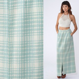 May include: A long, light blue skirt with a white and light blue plaid pattern. The skirt has a slit up the front and is made of a soft, woven fabric.