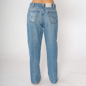 May include: A pair of light blue denim jeans with a straight leg fit. The jeans have a classic five-pocket design and a button fly.