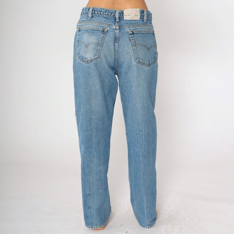 May include: A pair of light blue denim jeans with a straight leg fit. The jeans have a classic five-pocket design and a button fly.
