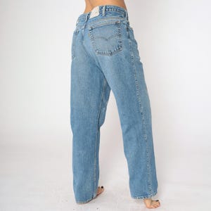 May include: A pair of light blue denim jeans with a straight leg fit. The jeans have a classic five-pocket design and a slightly faded wash.