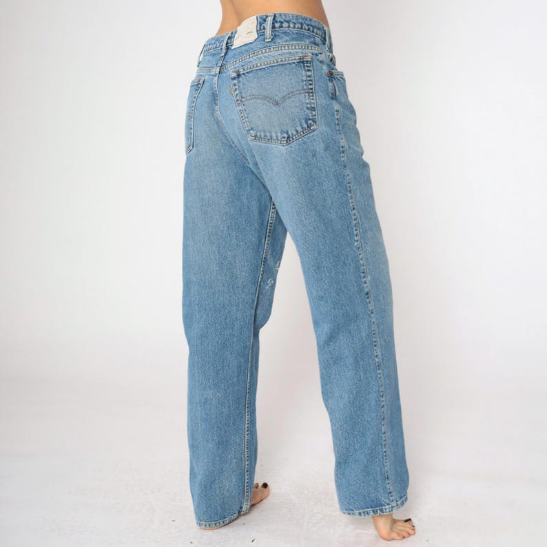 May include: A pair of light blue denim jeans with a straight leg fit. The jeans have a classic five-pocket design and a slightly faded wash.