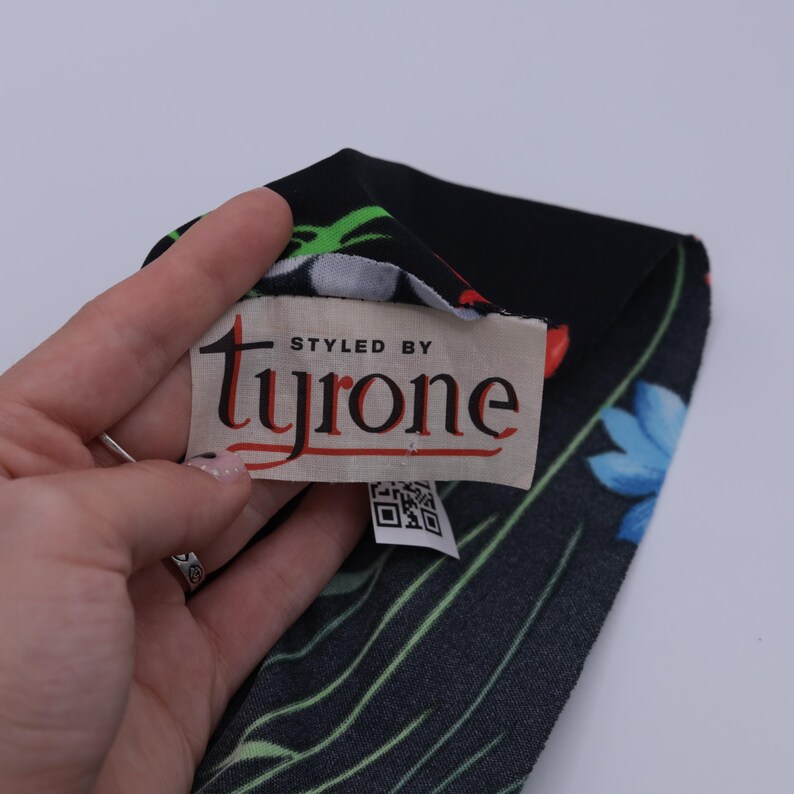 May include: A black fabric with a floral print and a white tag that says "Styled by Tyrone".