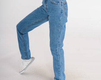 May include: A pair of light blue denim jeans with a straight leg fit. The jeans have a classic five-pocket style and a button fly.