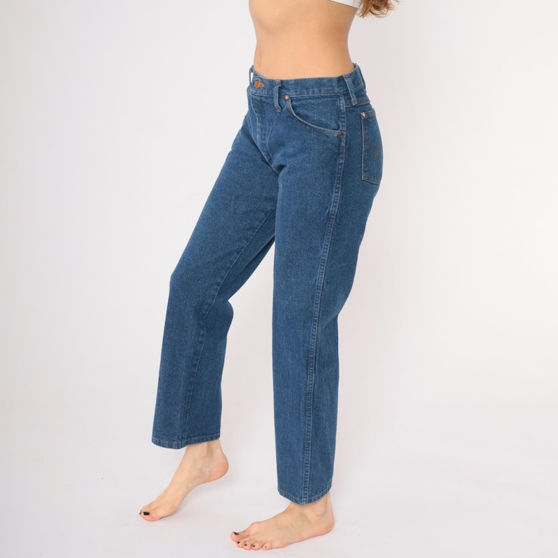 May include: A pair of blue denim jeans with a straight leg fit. The jeans have a high waist and a classic five-pocket style.