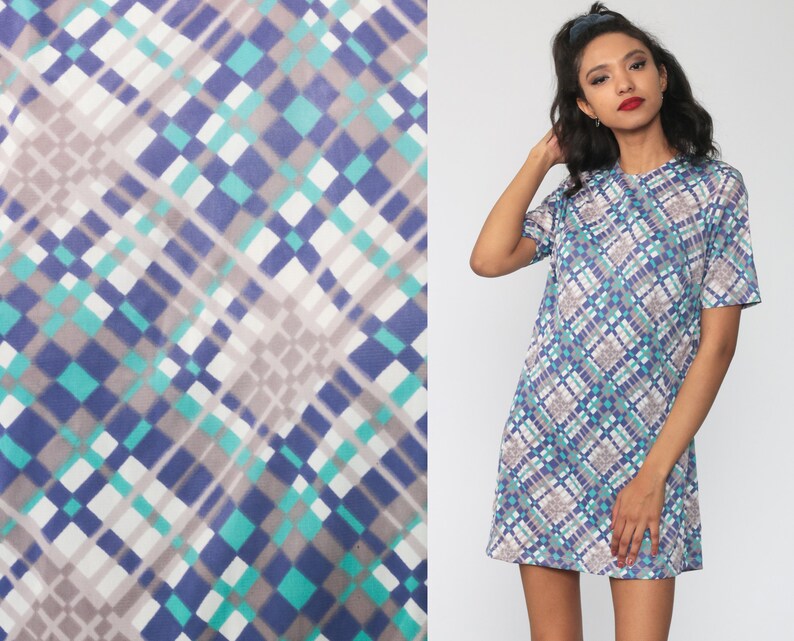 Puede incluir: Un vestido de manga corta con un patr&oacute;n geom&eacute;trico en tonos de azul, verde y blanco. El vestido tiene una silueta simple y cl&aacute;sica.