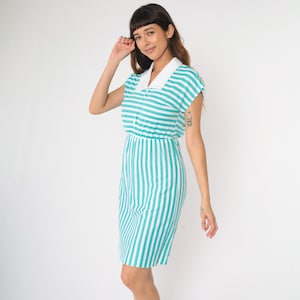 May include: A teal and white striped dress with a white collar and short sleeves. The dress has a fitted bodice and a slightly flared skirt.