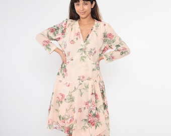 May include: A long-sleeved wrap dress with a floral print in shades of pink, green, and white. The dress has a V-neckline and a flowing skirt.