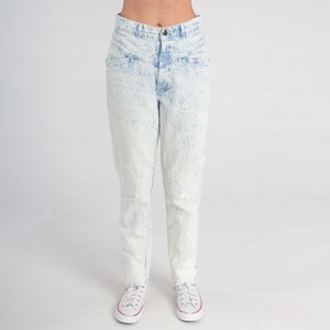 May include: Light blue acid wash denim jeans with a high waist and a straight leg fit.
