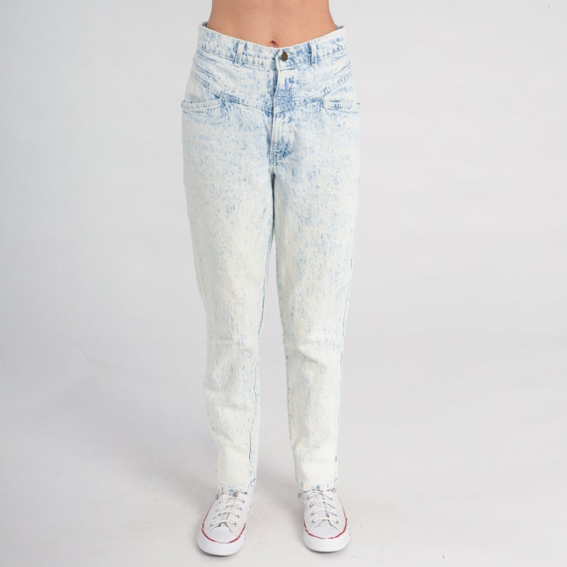May include: Light blue acid wash denim jeans with a high waist and a straight leg fit.