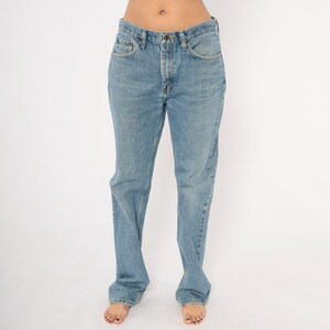 Peut inclure: Jean en denim bleu clair avec une conception classique &agrave; cinq poches. Le jean a une coupe droite et une fermeture &agrave; bouton et fermeture &eacute;clair. Le denim a un d&eacute;lavage d&eacute;color&eacute;, lui donnant un aspect vintage. Le jean est de style d&eacute;contract&eacute;.