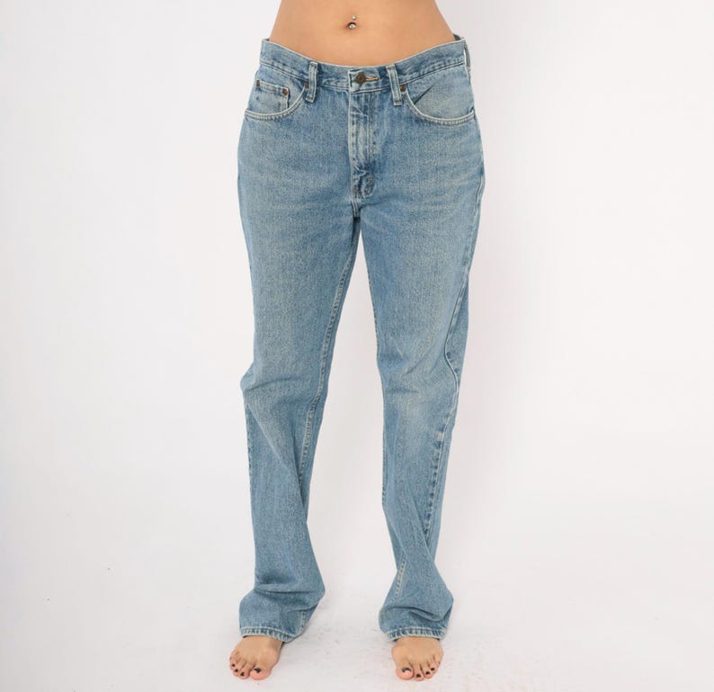 Peut inclure: Jean en denim bleu clair avec une conception classique &agrave; cinq poches. Le jean a une coupe droite et une fermeture &agrave; bouton et fermeture &eacute;clair. Le denim a un d&eacute;lavage d&eacute;color&eacute;, lui donnant un aspect vintage. Le jean est de style d&eacute;contract&eacute;.