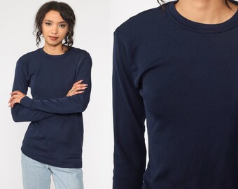 May include: A navy blue long-sleeved shirt with a crew neck.