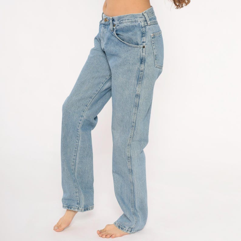 May include: Light blue denim jeans with a classic straight leg fit. The jeans feature a button and zipper closure, front and back pockets, and a faded wash. A timeless wardrobe staple.